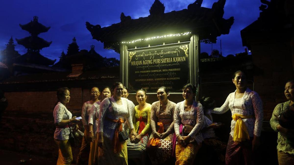Las mujeres balinesas se sientan frente a un templo mientras esperan participar en un ritual hindú antes de Nyepi en Klungkung, Bali, el miércoles 6 de marzo de 2019.