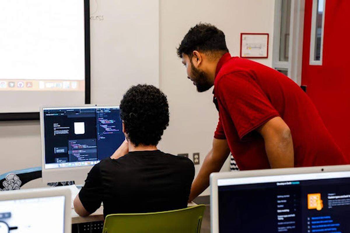 Los estudiantes trabajan en el desarrollo de aplicaciones para iOS utilizando computadoras Mac en el aula del programa Apple Swift de Miami Dade College.