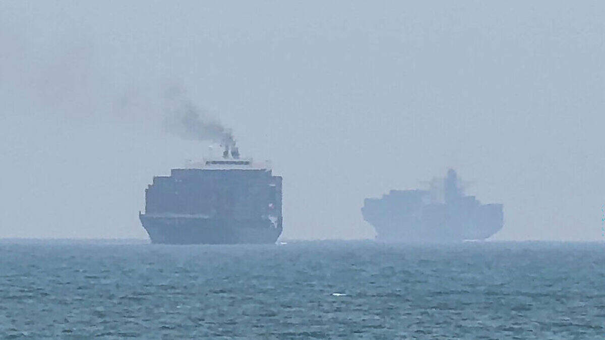 Esta imagen, tomada de una grabación de AFPTV el domingo 12 de julio de 2026, muestra buques de carga fondeando cerca del estrecho de Ormuz, frente a la costa oriental de los Emiratos Árabes Unidos, a la altura de Khor Fakkan.