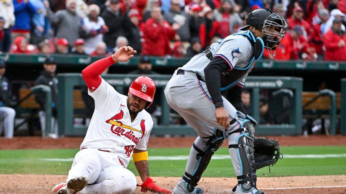 El pelotero de los Cardenales Iván Herrera anota una carrera en una jugada con el receptor de los Marlins de Miami Christian Bethancourt, en el séptimo inning del partido celebrado el 4 de abril de 2024 en San Luis.