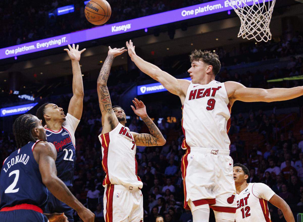 El jugador de los Clippers de Los Angeles, Jordan Miller (izq.), lucha por un rebote con Kel'el Ware (centro) y Pelle Larsson, del Heat, en el partido de la NBA celebrado el 1ro de diciembre de 2025 en Miami.