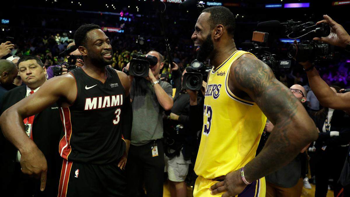 El jugador del Heat Dwyane Wade conversa con el atro de los Lakers LeBron James (der.) al final del juego del 10 de diciembre en Los Angeles.