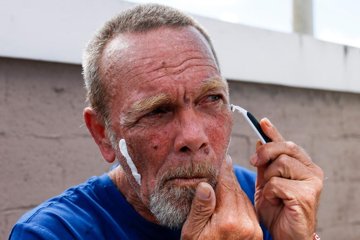 Alberto Cribeiro, un desamparado de 59 años, se afeita en las instalaciones móviles en el estacionamiento de la Iglesia Rescate en Hialeah, a la que Lillian Vázquez lleva desamparados para que coman, se bañen y les entreguen ropas.