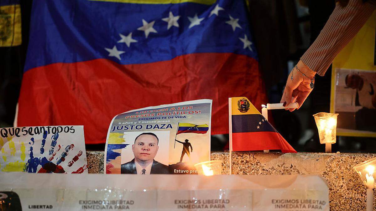 Una mujer enciende una vela durante una vigilia para exigir la liberación de todos los presos políticos, cerca de El Helicoide, una de las principales cárceles del régimen chavista, el sábado 17 de enero de 2026, en Caracas, Venezuela.