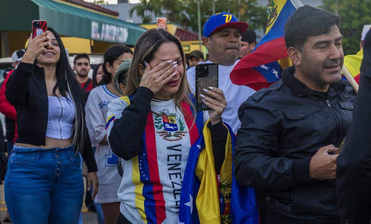 Jennifer Santillán reacciona mientras se unía a un grupo de venezolanos exiliados que viven en el sur de Florida celebrando frente a El Arepazo, en Doral, Florida, después de que Estados Unidos atacara Venezuela y capturara al líder venezolano Nicolás Maduro, el 3 de enero de 2026.