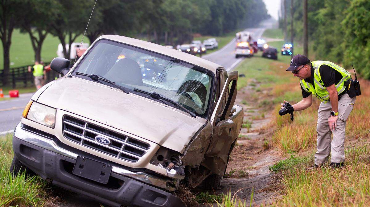 Florida Highway Patrol Cpl. Brett Detweiler takes photographs of the pickup truck involved in a deadly collision with a bus carrying agricultural workers in Marion County, Florida, on May 14, 2024.