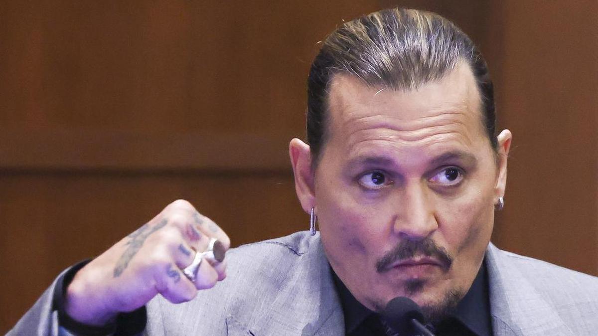 Actor Johnny Depp demonstrates how he says his ex-wife Amber Heard punched him, as he testifies in April during a defamation trial in Fairfax, Virginia.