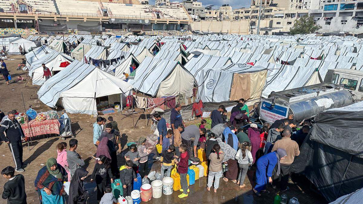 Refugiados palestinos hacen fila para tomar agua en un campamento en Gaza, el martes 19 de noviembre de 2024.
