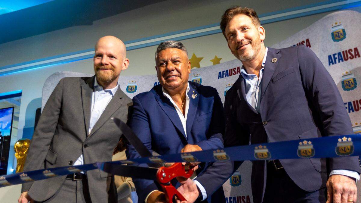 El presidente de la a Asociación del Fútbol Argentino Claudio Tapia (centro), el presidente de la Conmebol Alejandro Domínguez y el Secretario Adjunto de la FIFA  Mattias Grafstrom cortan la cinta que dejó inaugurada la nueva sede de la AFA en el vecindario de Wynwood, en Miami, el 7 de diciembre de 2023.