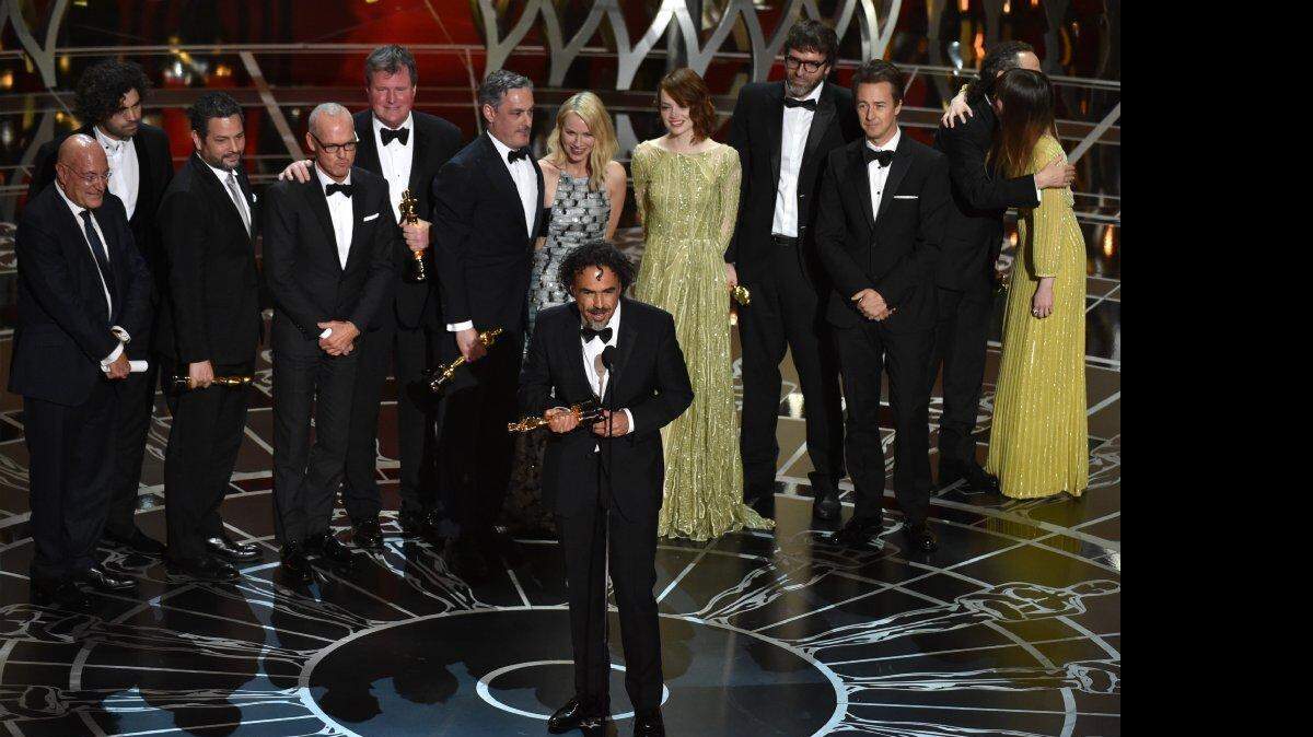 Alejandro G. Iñárritu, centro, y el elenco y el equipo de "Birdman o (La Virtud inesperado de la ignorancia)" aceptan el premio a la mejor película del año.