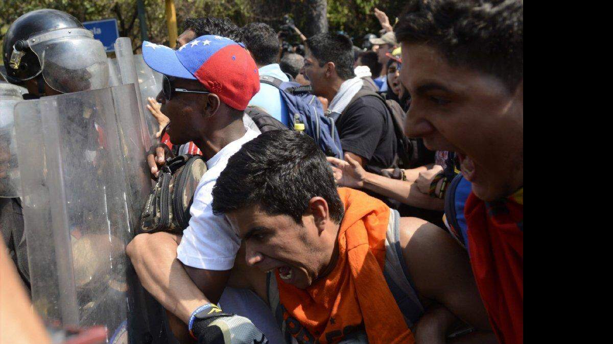 Estudiantes venezolanos chocan con la policía antidisturbios durante una protesta contra el gobierno del presidente Nicolás Maduro, en Caracas, el 12 de marzo de 2014. 