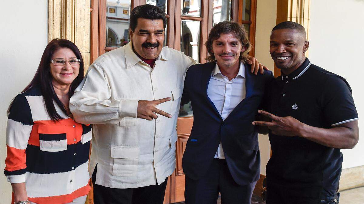 El presidente de Venezuela, Nicolás Maduro y la Primera Dama de Venezuela, Cilia Flores posan con actores estadounidenses Lukas Haas y Jamie Foxx (R) en el Palacio de Miraflores en Caracas el 4 de octubre de 2016. 