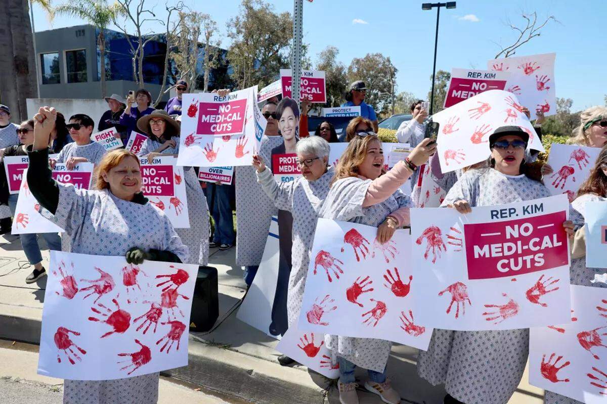 Manifestantes corearon y portaron pancartas frente a la oficina del representante Young Kim en Anaheim Hills para protestar contra el reciente proyecto de ley de reconciliación presupuestaria que, según afirman, podría conllevar recortes de miles de millones de dólares al SNAP, Medicaid y otros programas federales.