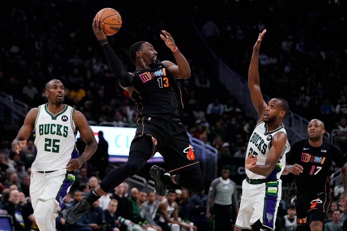 El jugador del Heat Bam Adebayo (izq. ) entra al aro ante la marca de Khris Middleton, de los Bucks de Milwaukee, en el partido celebrado el 2 de marzo de 2022 en Milwaukee.