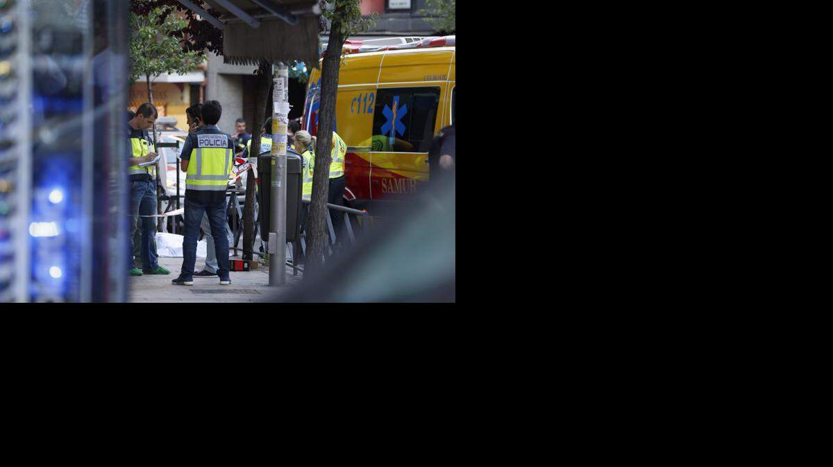 Miembros de los servicios de emergencia y de la Policía trabajan en un barrio de Madrid, donde tres personas fueron halladas muertas tras un incendio registrado en un despacho de abogados el 23 de junio. 