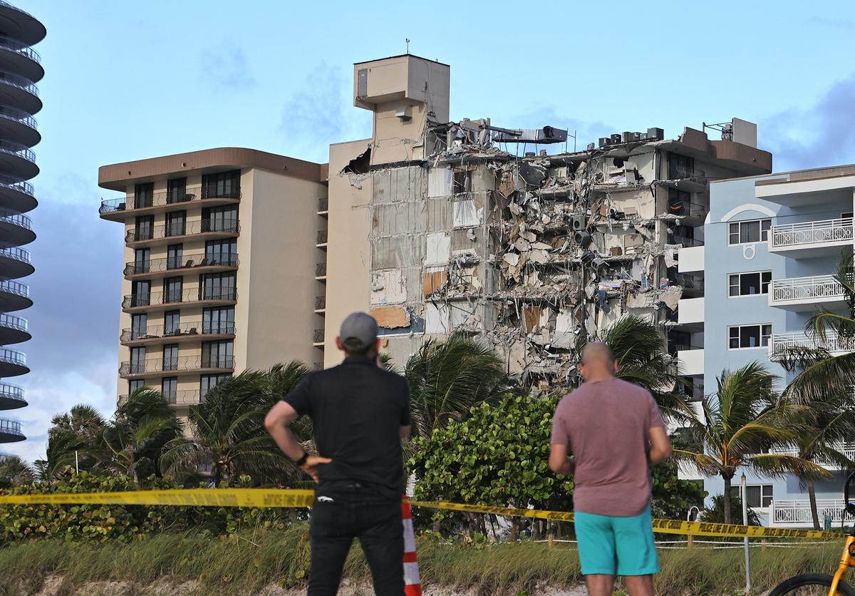 La gente mira los escombros en Champlain Towers South Condo en Surfside, ubicado en 8777 Collins Avenue, una parte del cual se derrumbó temprano en la mañana en Surfside, Florida, el jueves 24 de junio de 2021.
