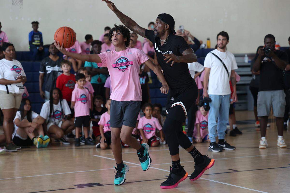 El joven de 14 años Hamid Moghaddam juega contra Udonis Haslem en el último día del campamento de baloncesto para niños que organizó el atleta del Heat en su alma mater, Miami Senior High School, el 21 de agosto de 2022.