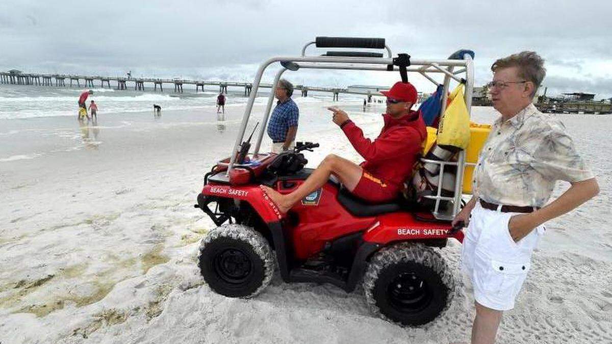 El salvavidas, Doug Brown instruye a los bañistas en la isla de Okaloosa en Fort Walton Beach, Florida, el lunes 28 de mayo de 2018, cuando la tormenta subtropical Alberto se acerca a la costa del Golfo.