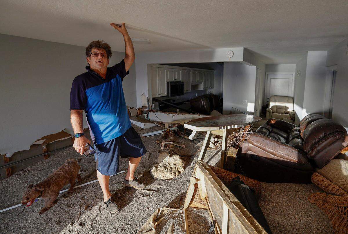 Adam Robinson esta de pie dentro de su casa sobre una pila de arena de playa que arrojó la causada por la marejada ciclónica de los huracanes Helene y Milton en el condominio de la playa Fisherman’s Cove en Siesta Key, Florida, el pasado 10 de octubre.