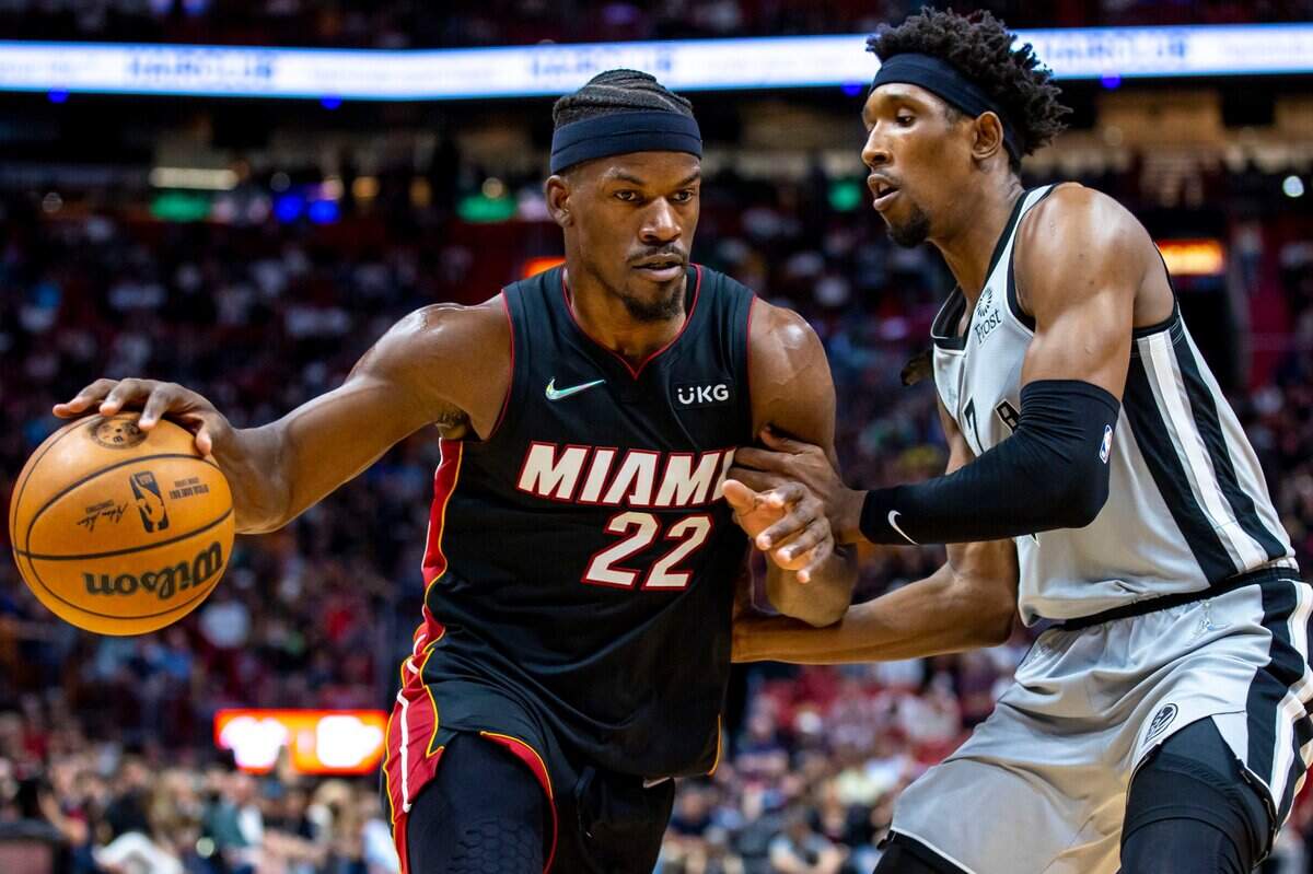 El jugador del Heat Jimmy Butler (izq.) trata de entrar al aro ante la marca de Josh Richardson, de los Spurs de San Antonio, en el partido efectuado el 26 de febrero de 2022 en Miami.