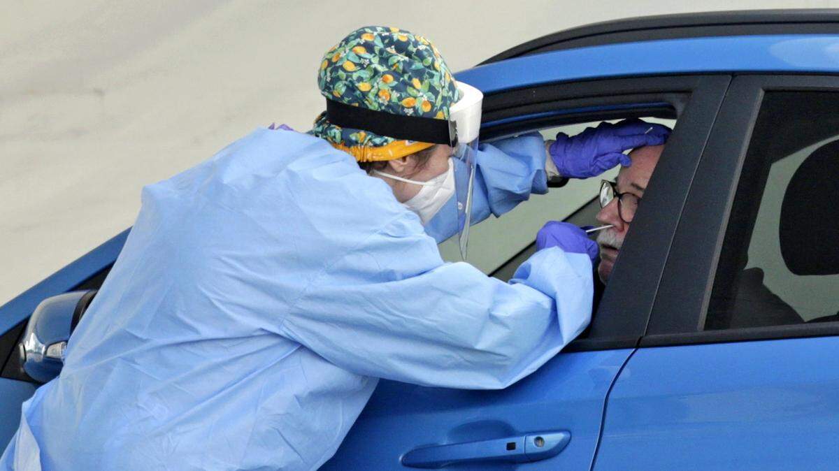 Un trabajador de salud realiza una prueba COVID-19 en un sitio de tránsito en Tamiami Park. Pero algunas personas mayores no tienen automóvil o no pueden salir de sus hogares, por lo que la Guardia Nacional de Florida comenzó a realizar pruebas en el hogar el viernes en algunas instalaciones residenciales para personas mayores en Miami.