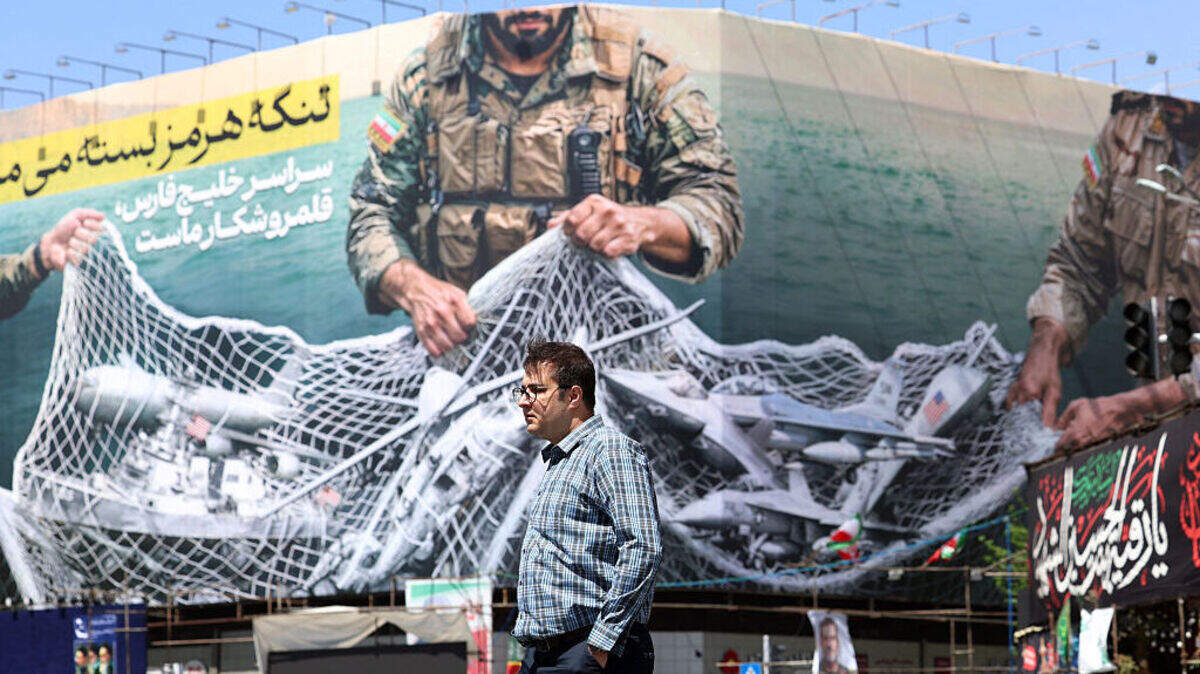 Un transeúnte pasa frente a una valla publicitaria con la frase “El estrecho de Ormuz permanece cerrado” en la plaza Enqelab, en Teherán, Irán, el domingo 5 de abril de 2026.
