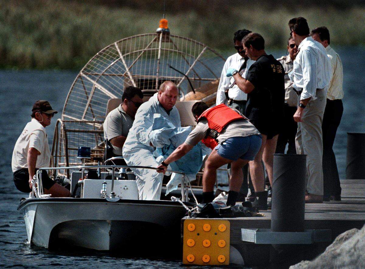 Empleados del Departamento del Médico Forense del Condado Broward sacan del agua el cádaver de Quatisha Maycock y lo llevan a la orilla del muelle de Alligator Alley.