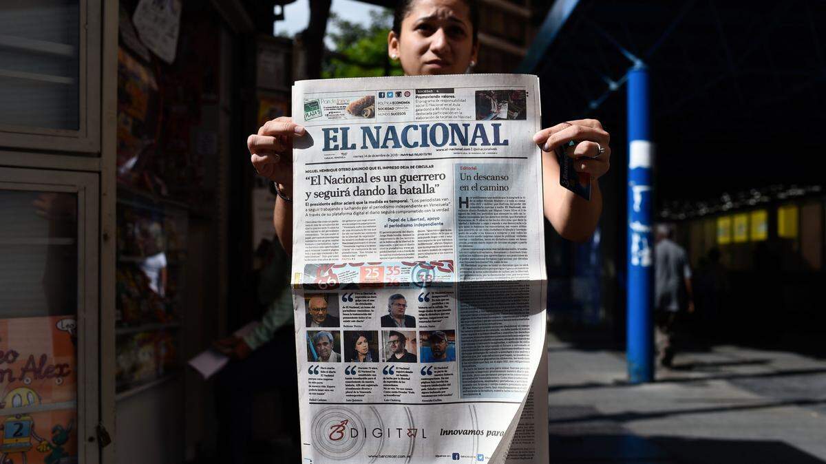 A woman shows the last printed edition of Venezuelan newspaper El Nacional with its front page reading “El Nacional is a warrior and will keep on fighting” at a newspaper stand in Caracas on Dec. 14, 2018. The print edition of the Venezuelan anti-government daily El Nacional appeared for the last time Friday, shutting down due to a mixture of political pressure and a crippling economic crisis that left it unable to source newsprint.