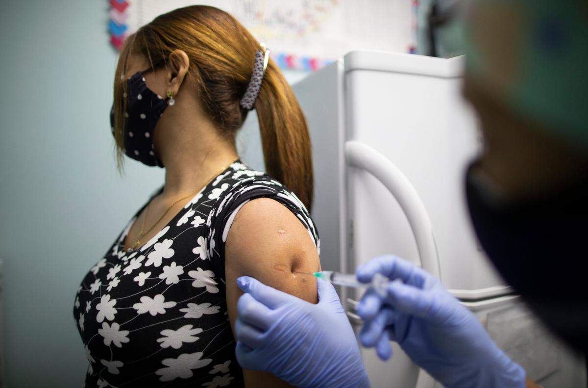 Una enfermera inyecta a un trabajador de la salud con una dosis de la vacuna Sinopharm contra el COVID-19, en un centro de salud en Caracas, Venezuela, el domingo 7 de marzo de 2021.