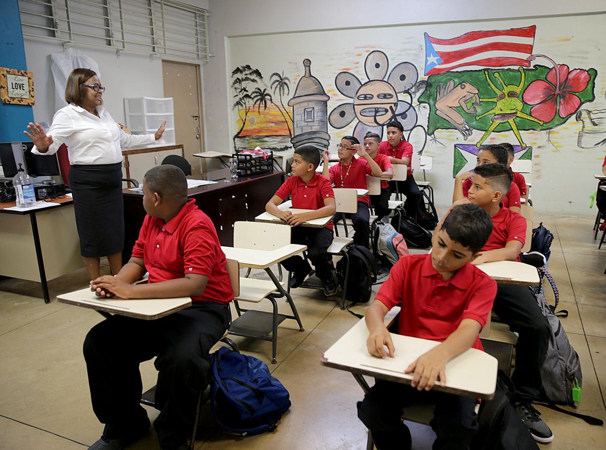 La directora Victoria García Burgos da la bienvenida a estudiantes de sexto grado en la escuela intermedia pública Rosa Costa Valdivieso, en la localidad puertorriqueña de Yabucoa, el lunes 13 de agosto del 2018.