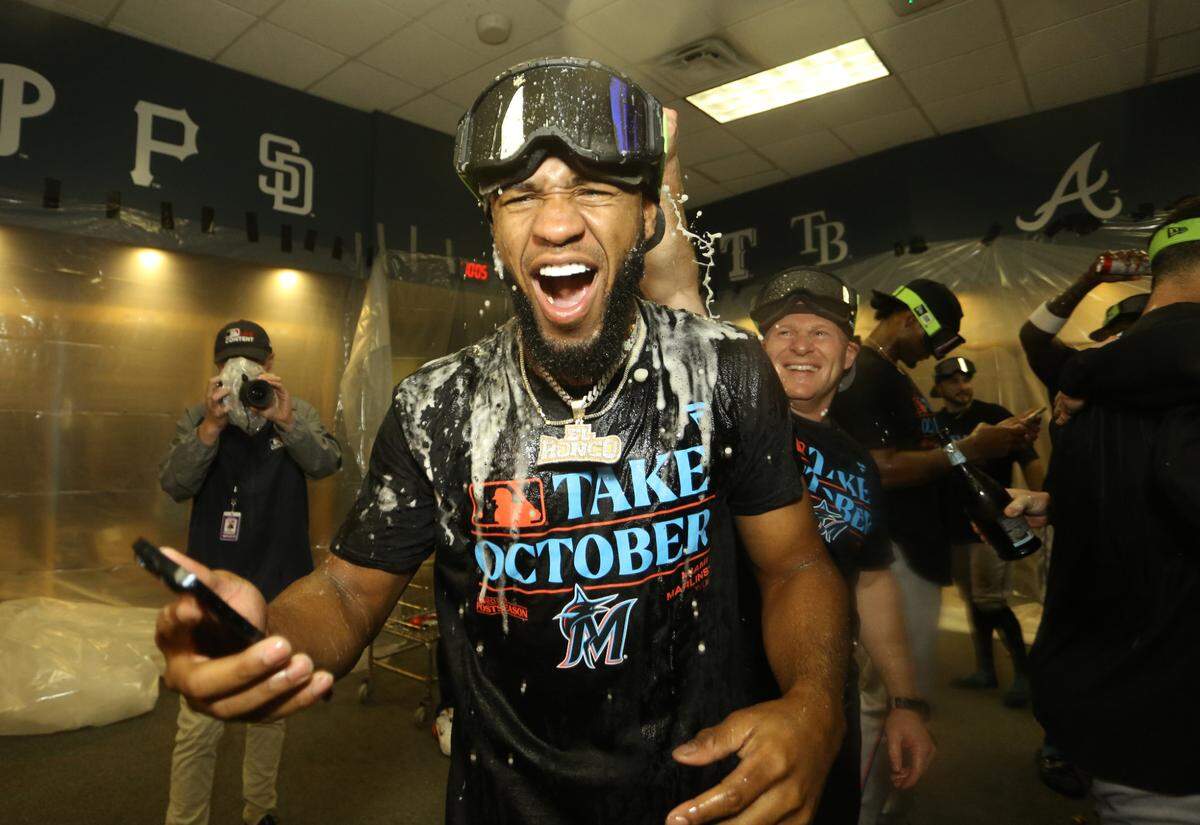 El jardinero de los Marlins Bryan de la Cruz celebra con sus compañeros de equipo tras alcanzar el boleto a la postemporada, el 30 de septiembre de 2023 en Pittsburgh.