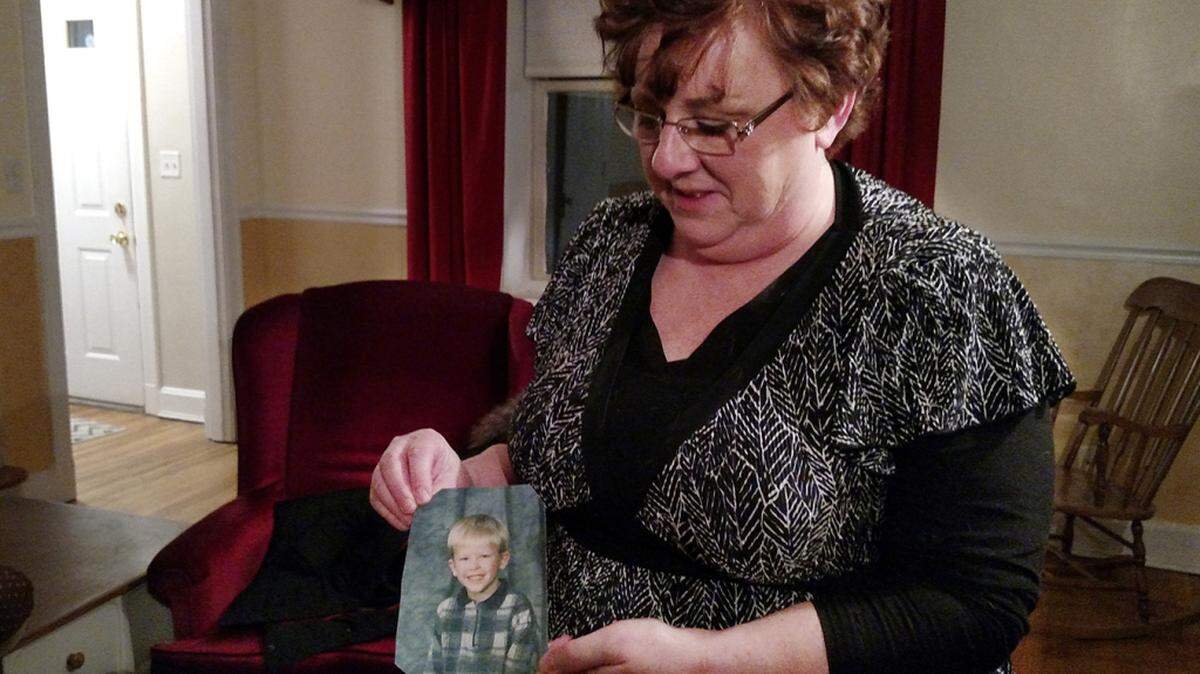 Toni Hoy, en su casa en Rantoul, Illinois, sostiene una foto de Daniel, que ahora tiene 24 años, cuando era pequeño. En un recurso desesperado para que Daniel recibiera tratamiento psiquiátrico, los Hoy renunciaron a la custodia en 2007, y lo devolvieron al estado. Según dijeron, fue la decisión más desgarradora que tuvieron que tomar en sus vidas. (Christine Herman/Illinois Public Media)