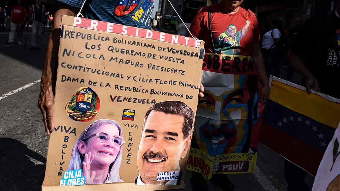 Simpatizantes del gobierno sostienen pancartas que representan a Nicolás Maduro y Cilia Flores durante una protesta como parte del Día de la Juventud de Venezuela, el 12 de febrero de 2026, en Caracas, Venezuela.