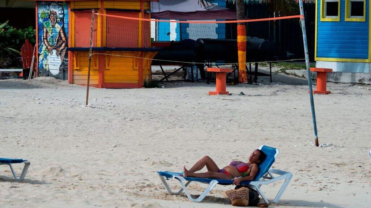 Una turista descansa en una tumbona en una playa de Nassau, en las Bahamas, el 12 de septiembre de 2019, tras el paso del huracán Dorian.