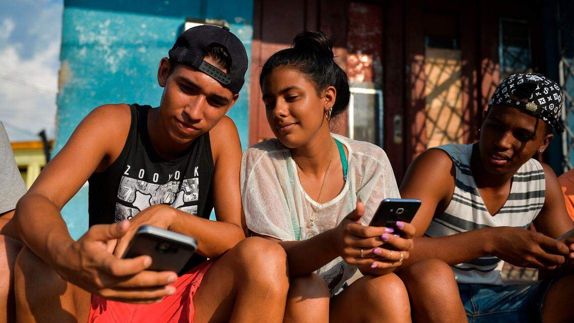 Foto de archivo de jóvenes cubanos observando sus teléfonos móviles en La Habana, Cuba, el 6 de junio de 2019, en un contexto de uso de redes sociales e Instagram vinculado a concursos, creatividad, talento y participación digital impulsada por la embajada alemana.