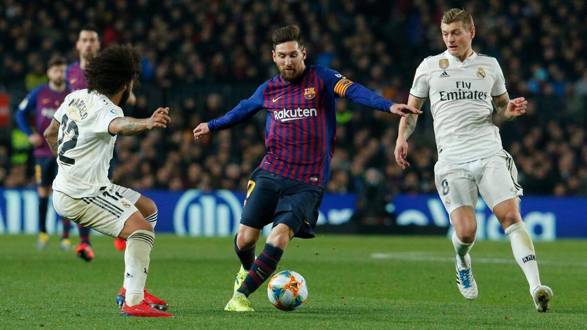 El delantero de Barcelona Lionel Messi (centro) conduce la pelota ante la marca de Marcelo (izq.) y Toni Kroos, del Real Madrid, en el partido de ida de la semifinal de la Copa del Rey, celebrado el 6 de febrero de 2019.