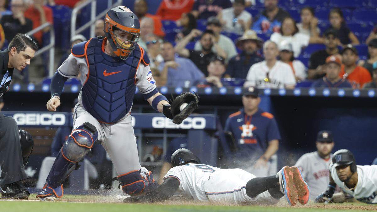 El torpedero de los Marlins Xavier Edwards (9) llega quieto a home en la jugada con el receptor de los Astros de Houston Víctor Caratini, en el primer inning del partido celebrado el 6 de agosto de 2025 en Miami.