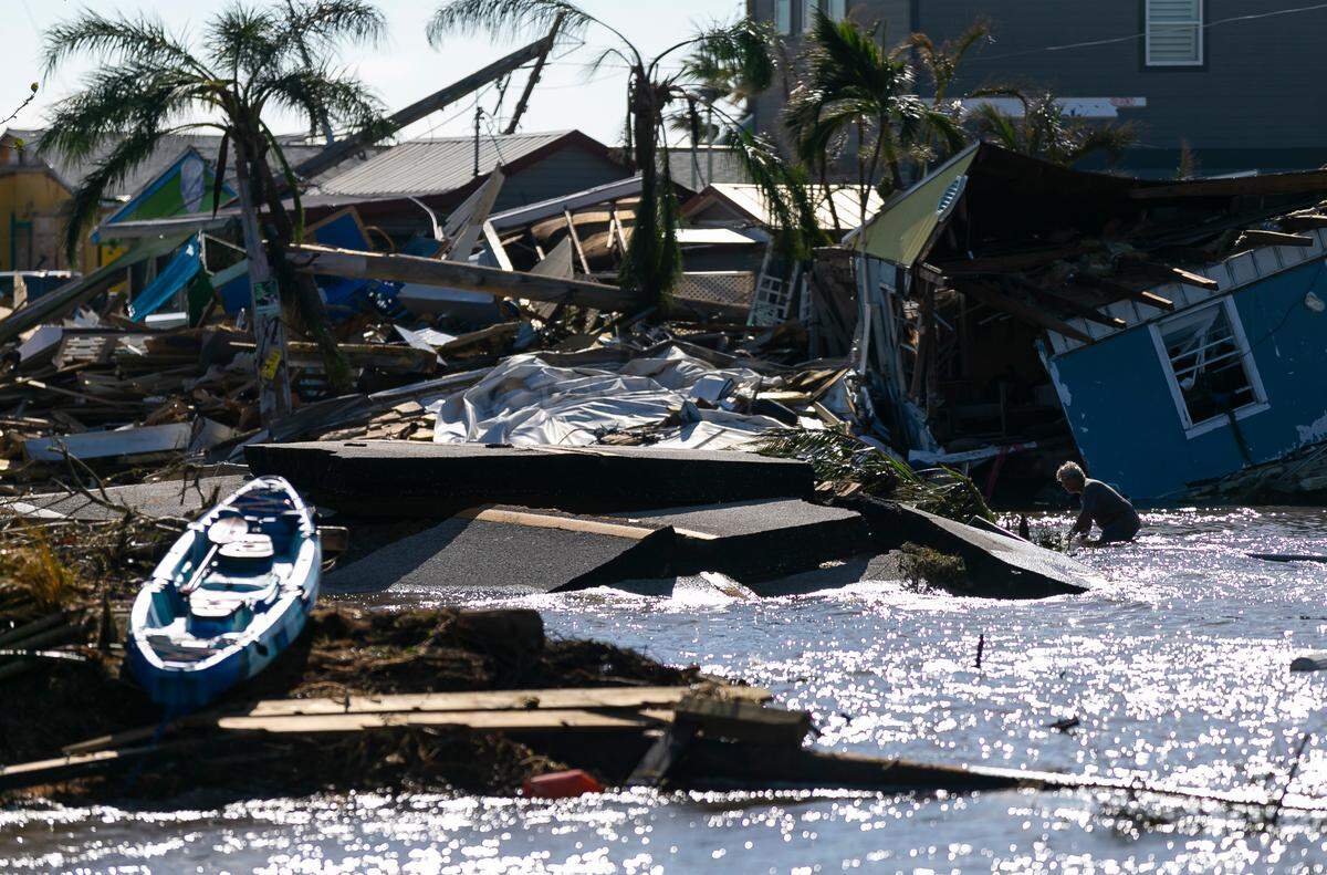 Un hombre camina a través del agua en una zona de Pine Island Road el jueves 29 de septiembre de 2022 en Matlacha, Florida. El huracán Ian tocó tierra en la costa suroeste de Florida como categoría 4 el día anterior dejando las áreas afectadas con calles inundadas, árboles caídos y escombros esparcidos.