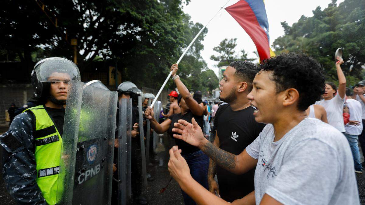 Manifestantes protestan contra la reelección de Nicolás Maduro y se enfrentan a agentes policiales antimotines el lunes 29 de julio de 2024, en Caracas.