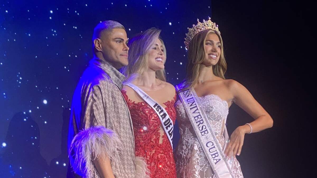 Prince Julio César y Lina Luaces, Miss Universe Cuba 2025, después de poner la banda oficial de Isla de la Juventud a Mia Dio,una de las concursantes de Miss Universe Cuba 2026, el 13 de julio en Teatro Miami.