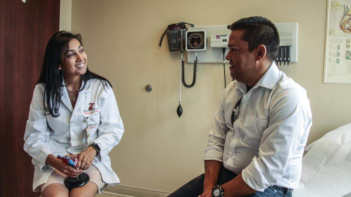 La Dra. Sandra Chaparro, cardióloga de University of Miami Health System, en la consulta con Octavio Rosa, quien sufre de diabetes y tuvo que someterse a un trasplante de corazón.