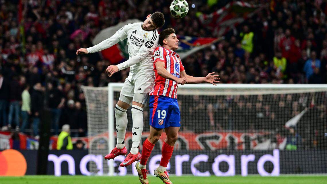 El delantero del Atlético del Madrid Julian  Álvarez (der.) y Federico Valverde, del Real Madrid, luchan por un balón durante un partido de la Liga de Campeones, el 12 de marzo de 2025.