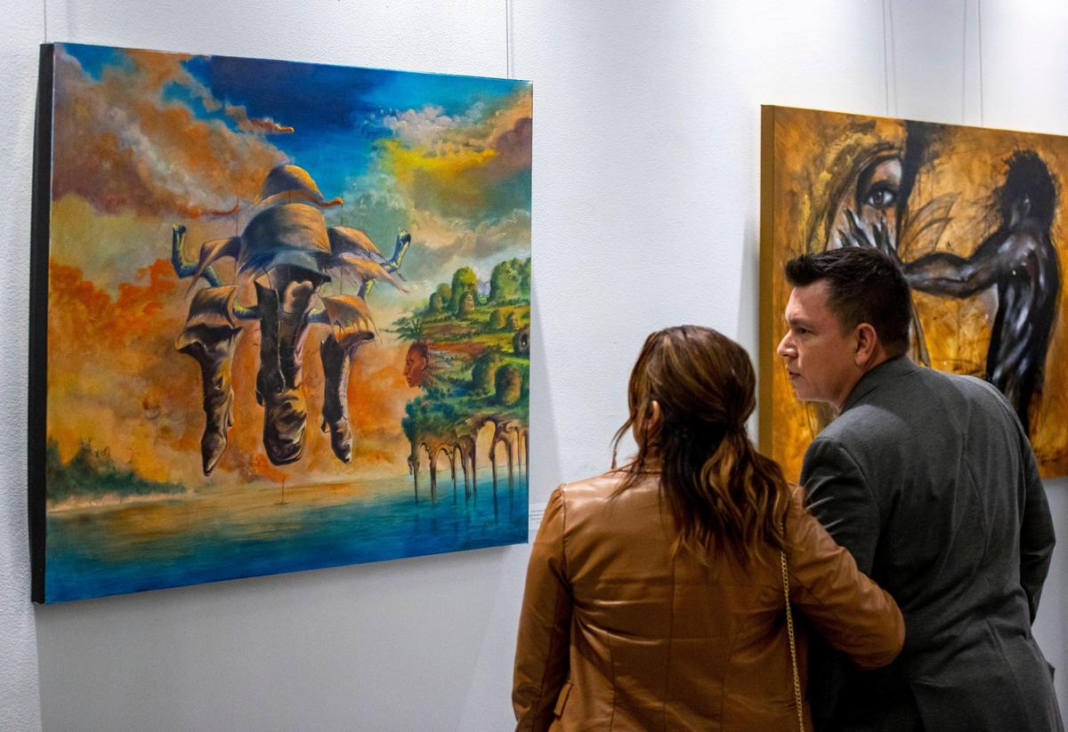 Personas observan obras de arte durante la exhibición de artistas latinoamericanos en el Milander Center en Hialeah, Florida, viernes 30 de septiembre de 2022.