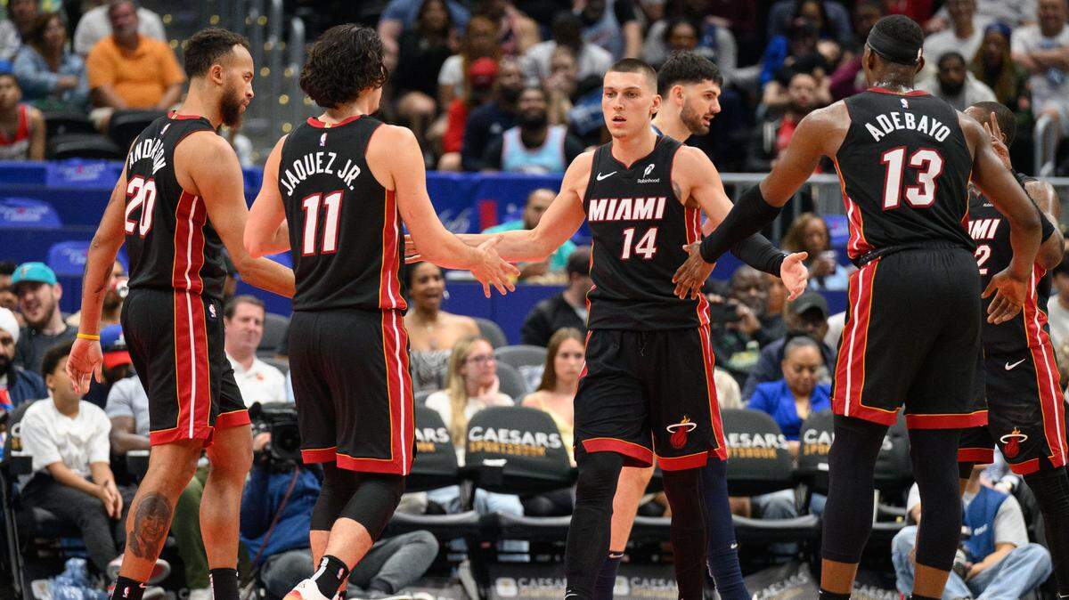Los basquetbolistas del Heat de Miami Tyler Herro (#14), Bam Adebayo (#13) y Jaime Jáquez Jr. (#11) reaccionan durante una jugada en el partido ante los Wizards, celebrado el 31 de marzo de 2025 en Washington.