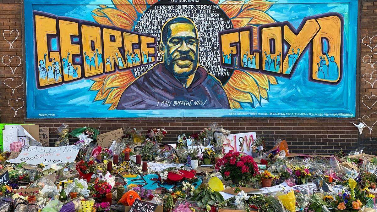 Un monumento improvisado para George Floyd incluye un mural, tarjetas y flores cerca del lugar donde murió mientras estaba bajo custodia policial en Minneapolis.
