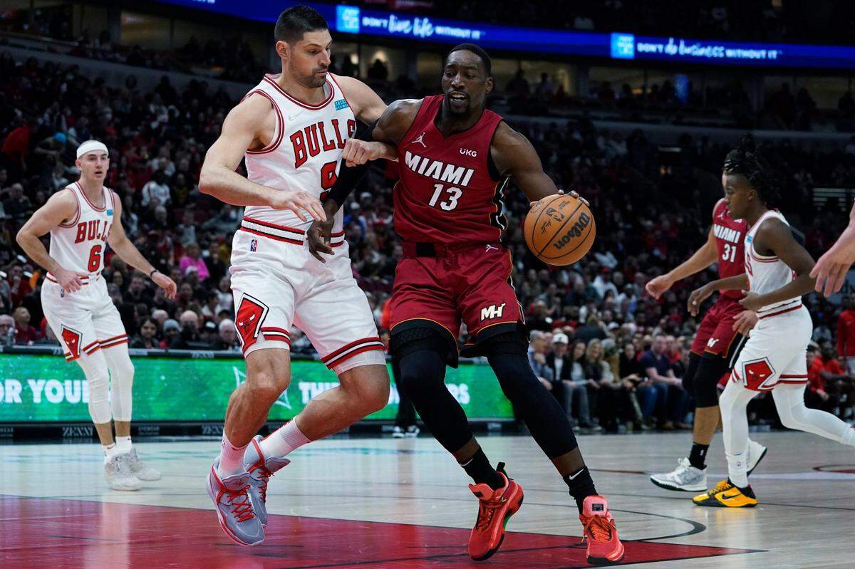 El jugador del Heat Bam Adebayo (der.) entra al aro ante la marca de Nikola Vucevic, de los Bulls, en el partido celebrado el 2 de abril de 2022 en Chicago.