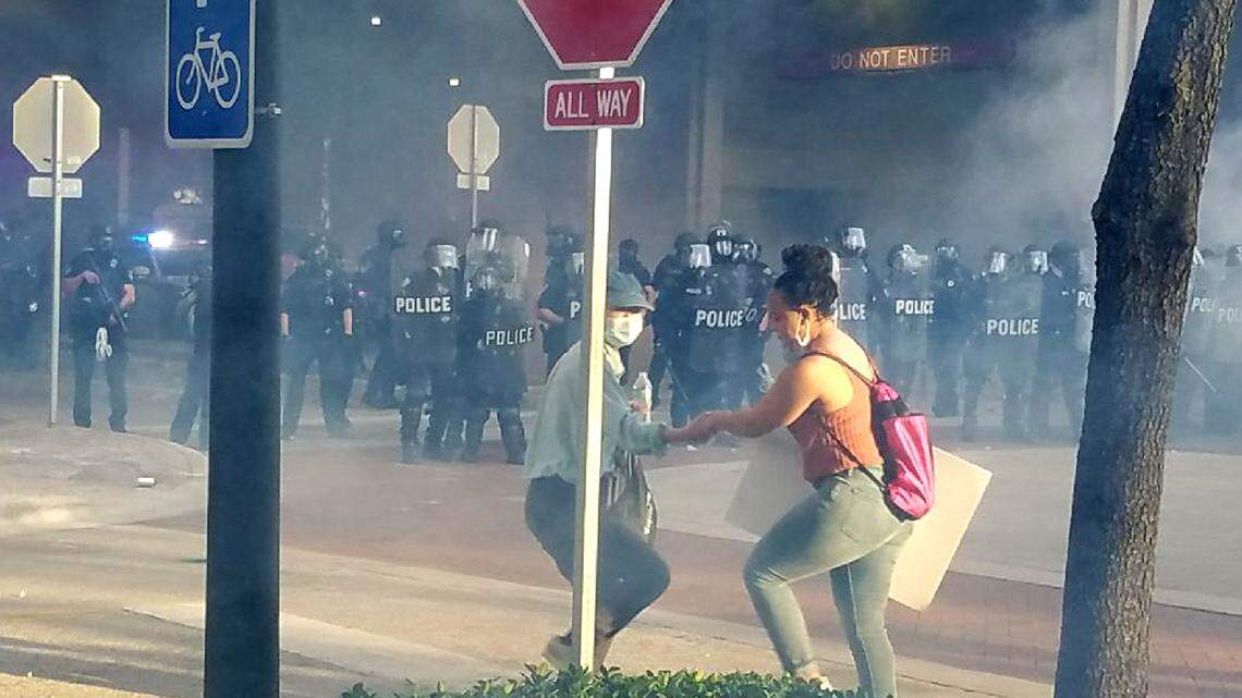 LaToya Ratlieff flees tear gas moments before she is hit in the face with a rubber bullet.