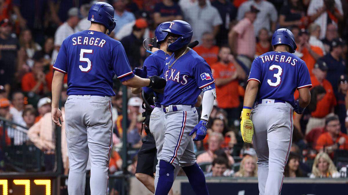 El jardinero de los Rangers de Texas Adolis García recibe el saludo de sus compañeros de equipo tras pegar un jonrón con bases llenas en el noveno inning ante los Astros, en el sexto partido de la Serie de Campeonato de la Liga Americana, celebrado el 22 de octubre de 2023 en Houston.