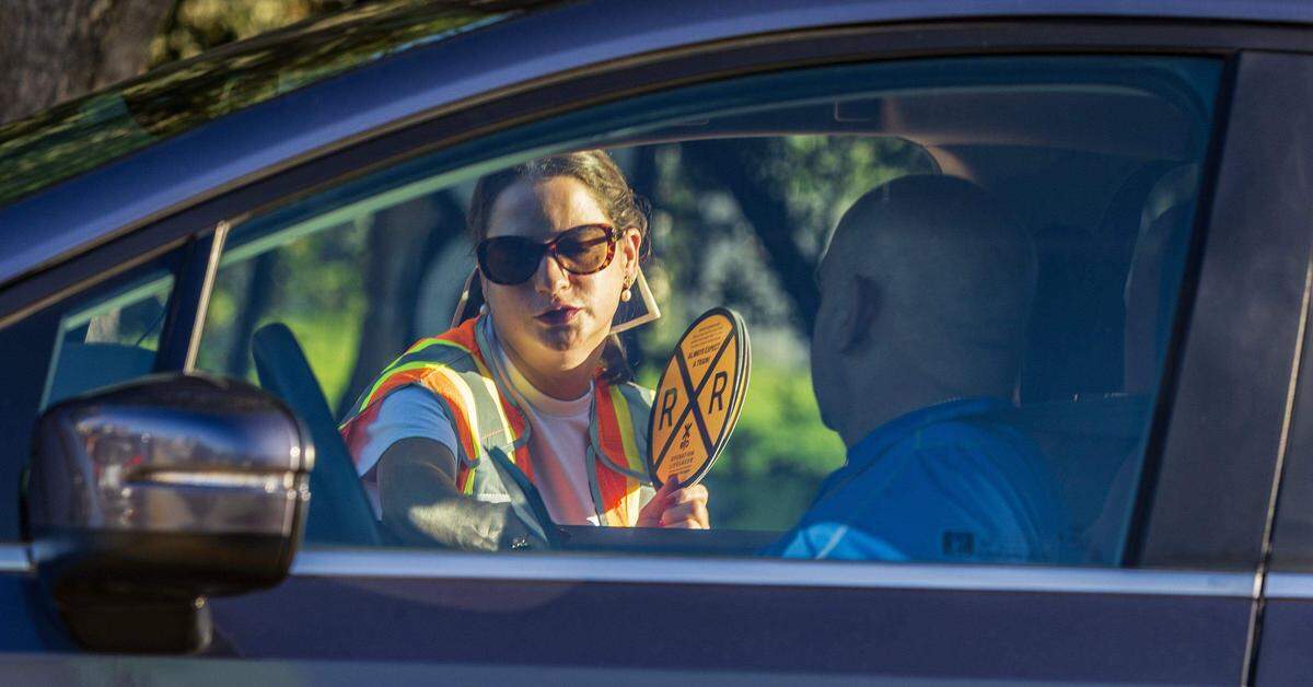 Ana Pérez, del Departamento de Transporte de la Florida, le entrega folletos de seguridad a los conductores durante la Operación Vía Libre, en septiembre, cuyo objetivo es reducir lesiones y muertes.