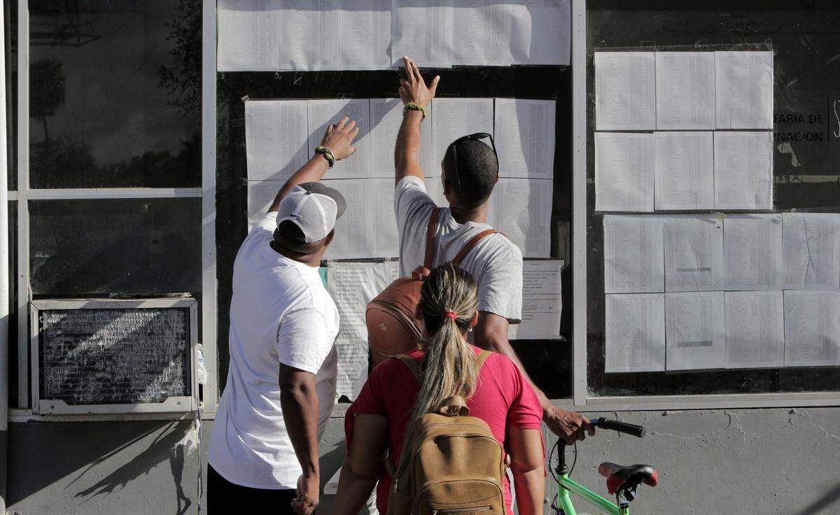 Cuban migrants check their status on the list posted by the entrance to the Gateway International Bridge in Matamoros, Mexico.